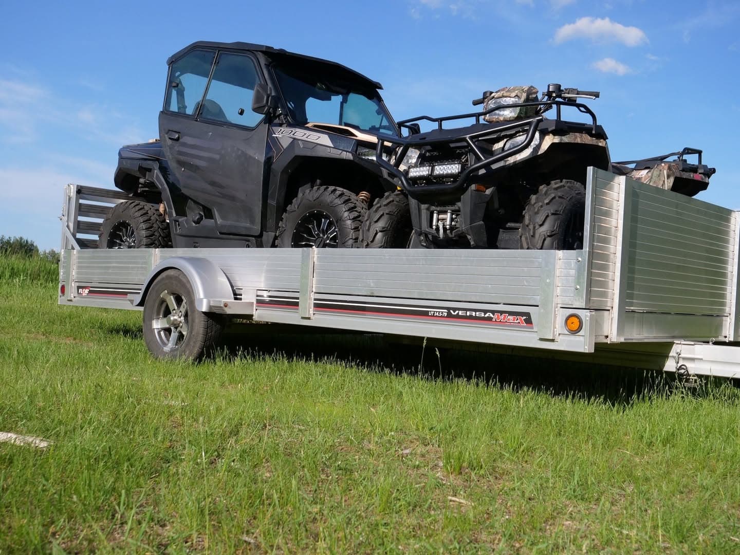 FLOE Versa-Max UT aluminum trailer loaded with a side-by-side and an ATV